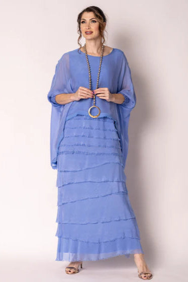Woman wearing a blue layered dress with a plain background