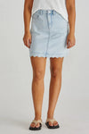 Light blue denim skirt worn by a person on a plain background