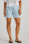Person wearing light blue shorts on a plain background