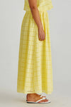 Yellow checkered dress worn by a person on a plain background