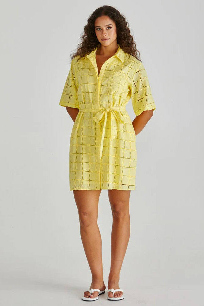 Woman wearing a yellow checkered dress on a gray background