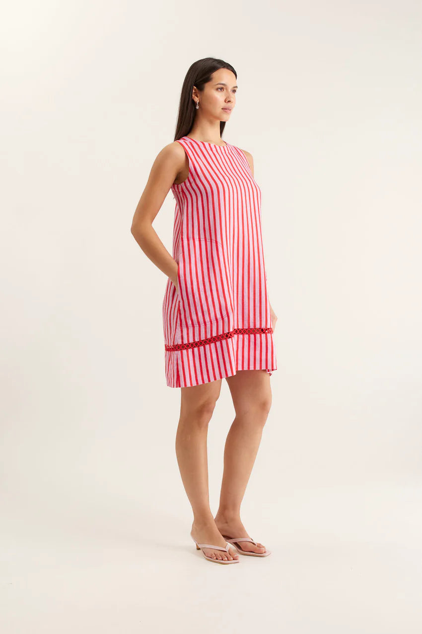 Woman wearing a red and white striped dress on a plain background