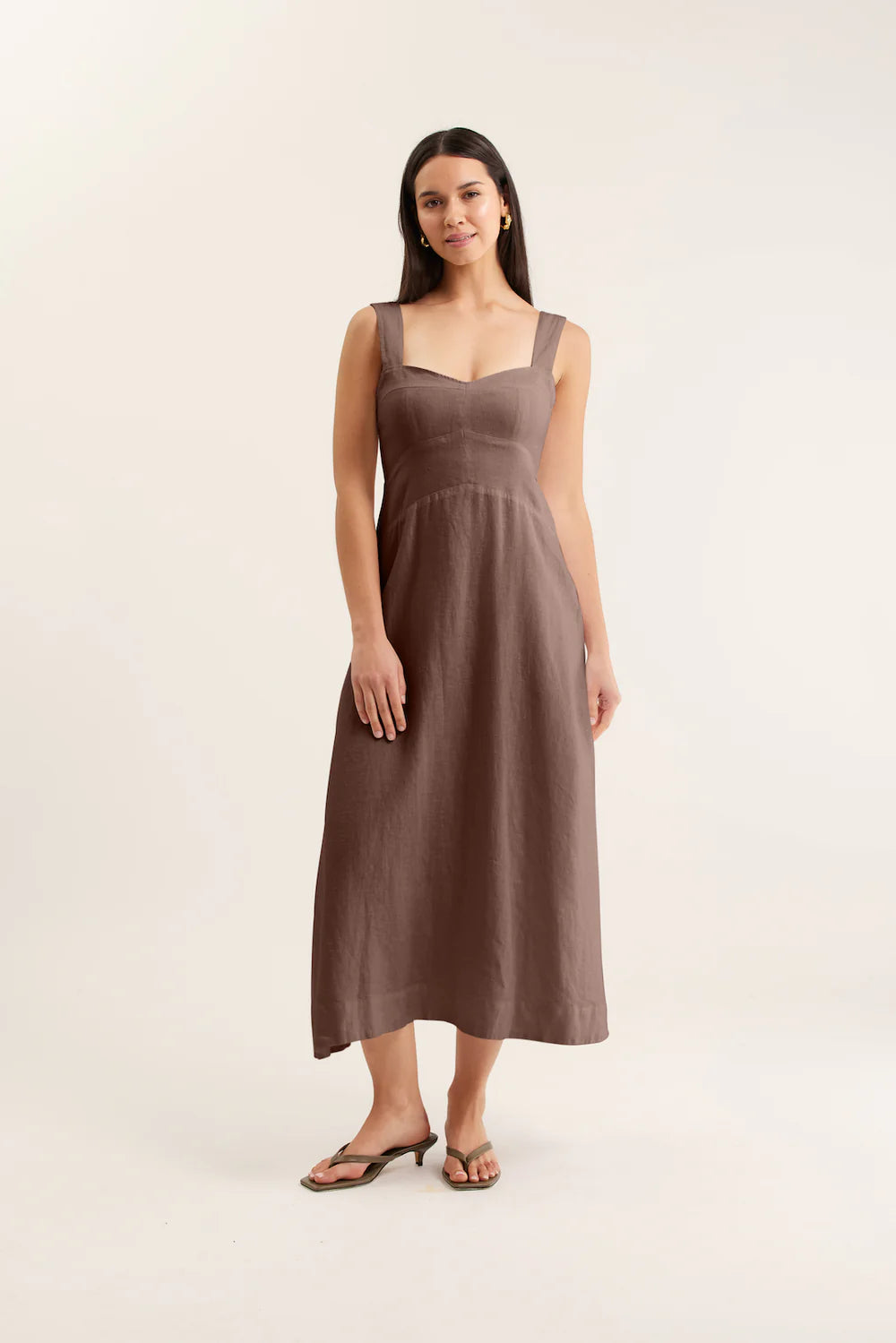 Woman wearing a brown dress against a white background