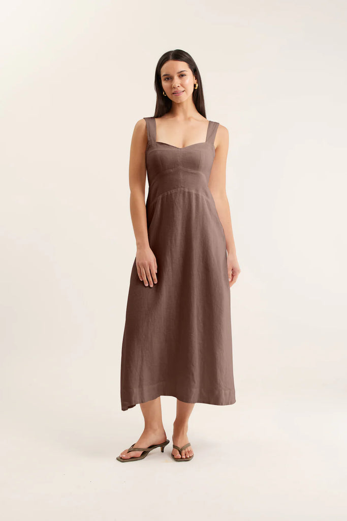 Woman wearing a brown dress against a white background