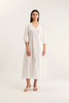 Woman wearing a white dress on a plain background