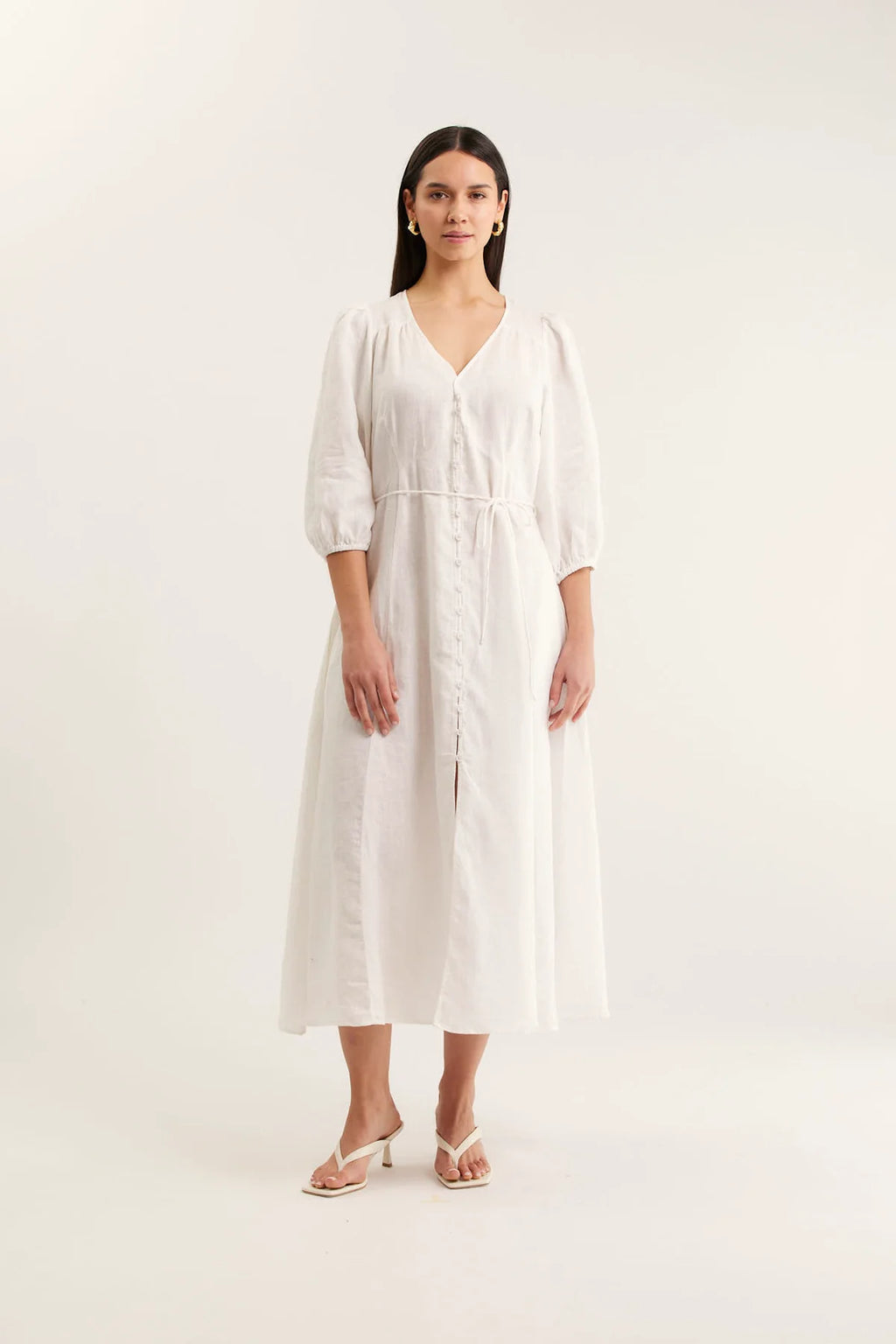 Woman wearing a white dress on a plain background