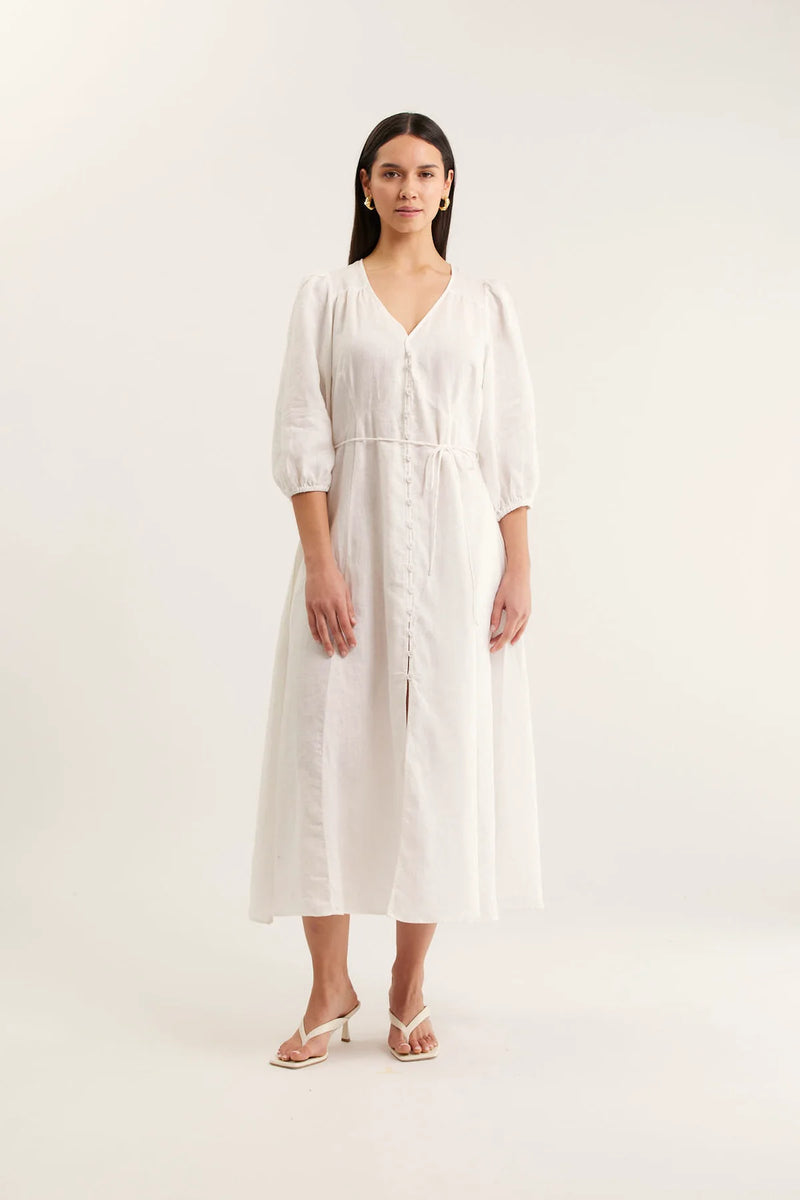 Woman wearing a white dress on a plain background