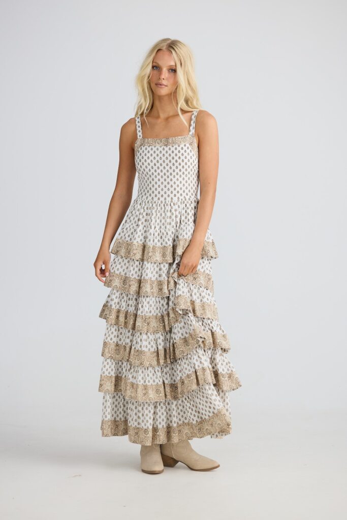 Woman wearing a tiered dress with polka dot pattern on a white background