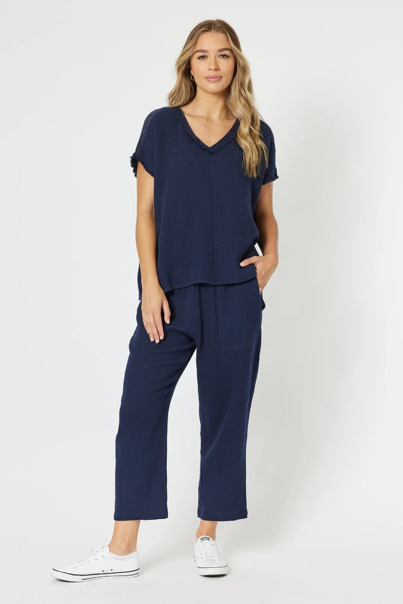 Woman wearing a navy blue outfit with white sneakers on a white background