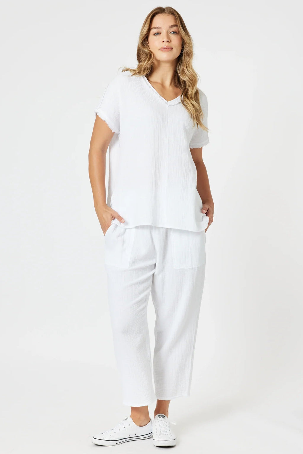 Woman wearing a white outfit with a plain background