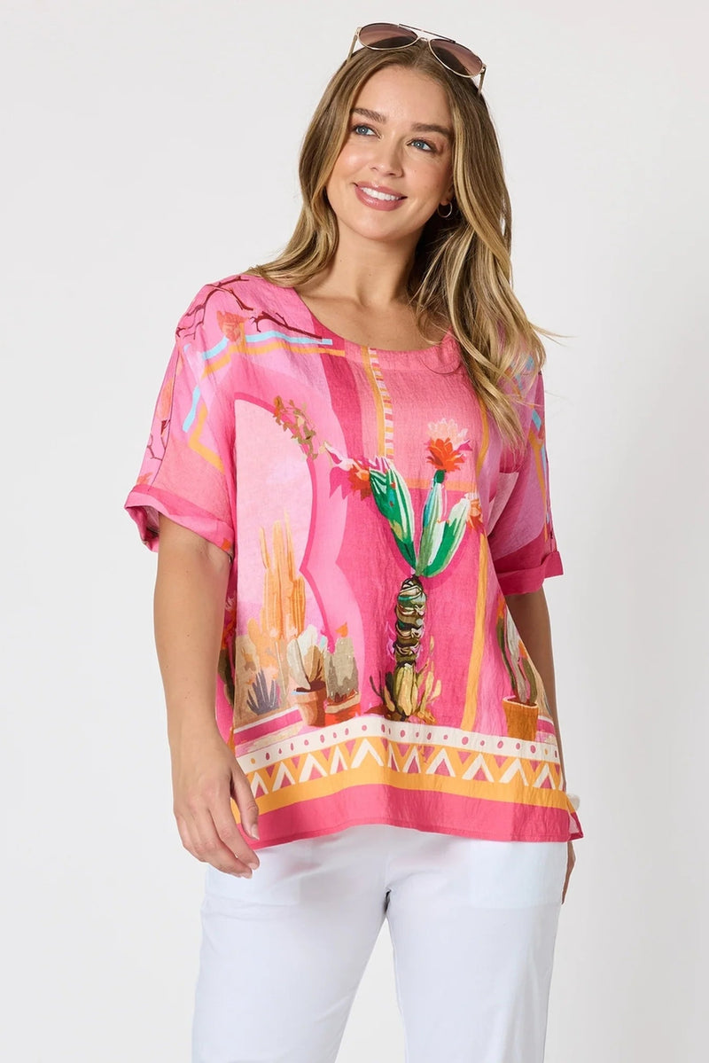 Woman wearing a pink hoodie with tropical design on a white background