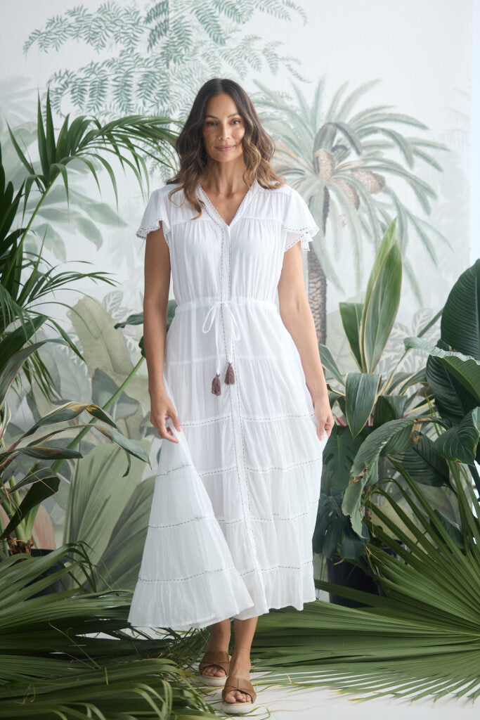 Woman in a white dress standing among tropical plants