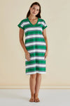 Woman wearing a green and white striped dress against a beige background