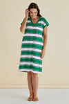 Woman wearing a green and white striped dress against a beige background