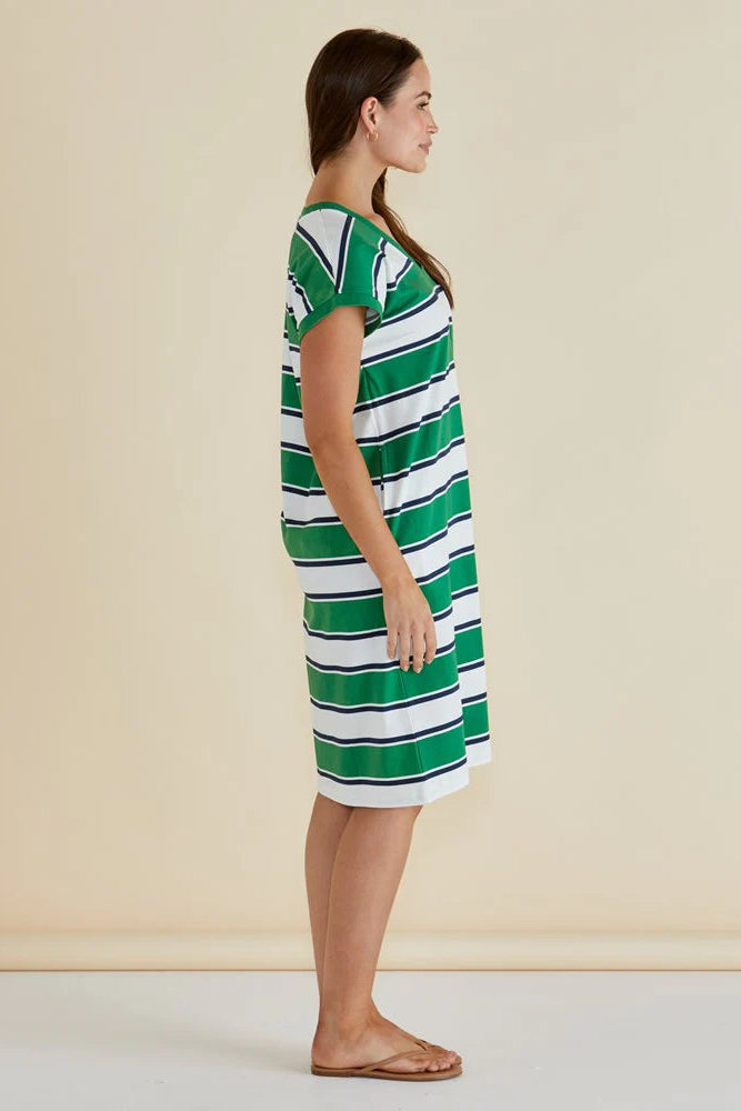 Woman wearing a green and white striped dress against a beige background
