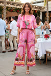 Woman in a pink outfit with cactus design at an outdoor event