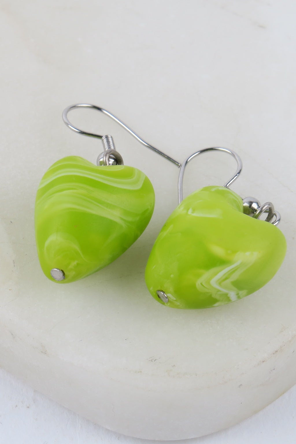 Green marbled heart-shaped earrings on a white background