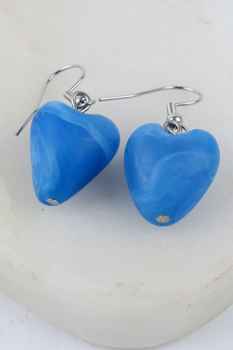 Blue heart-shaped earrings on a white background