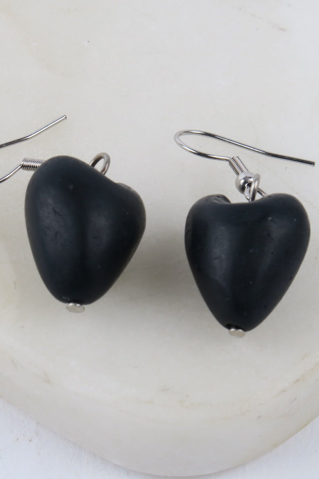 Black heart-shaped earrings on a white background