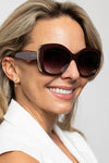 Woman wearing dark sunglasses with a blurred background