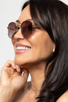 Woman wearing sunglasses with a plain background