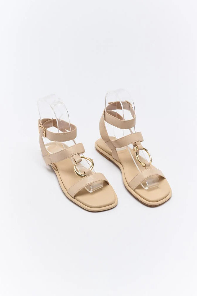 Pair of beige sandals on a white background