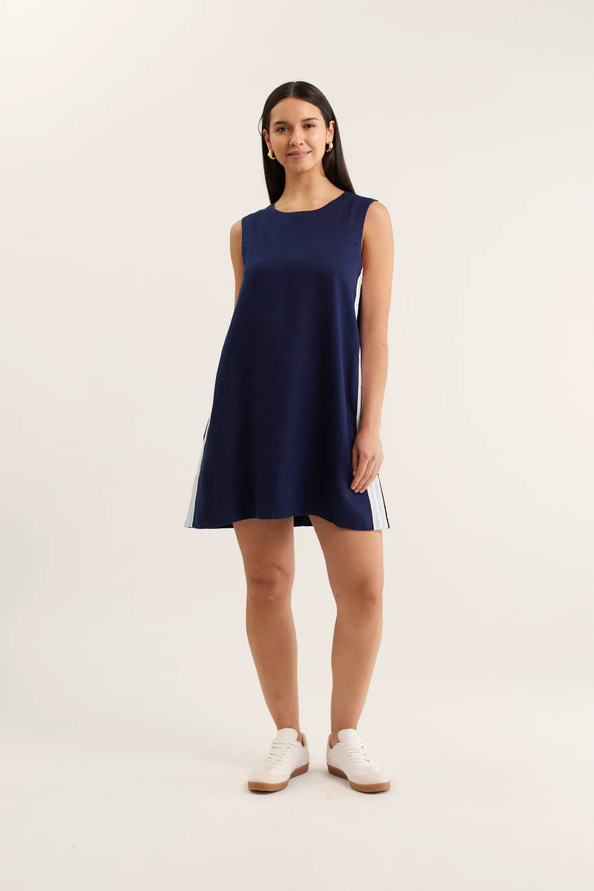 Woman wearing a navy sleeveless dress on a white background