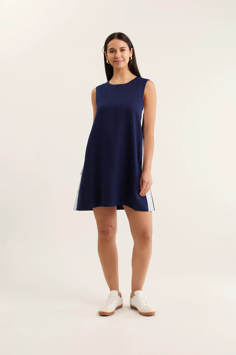 Woman wearing a navy sleeveless dress on a white background
