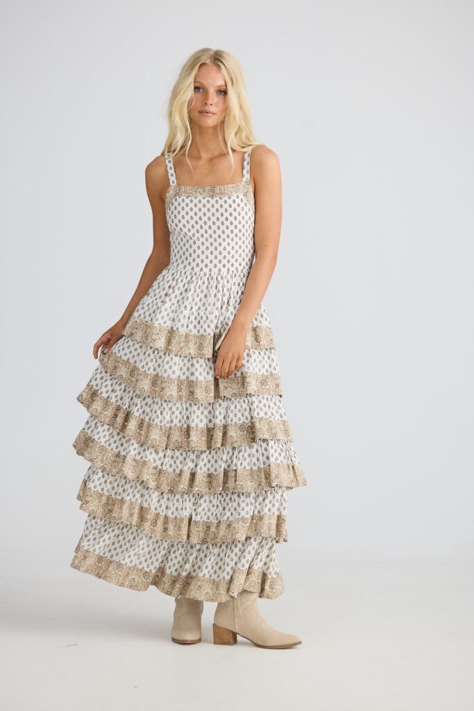 Woman wearing a polka dot dress with ruffled layers on a white background